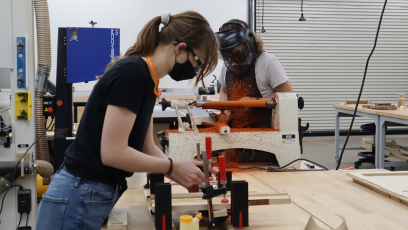 An image of a female Phoenix Forge member using woodworking tools. 