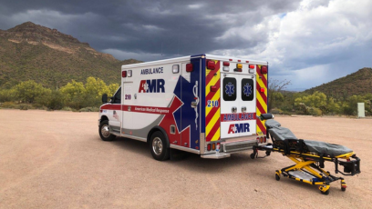 An image of an AMR ambulance and a stretcher in a desert setting 
