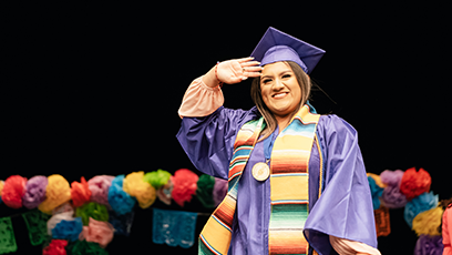 An image of a female student wearing a graduation cap, gown, and colorful stole attending a Hispanic Convocation Ceremony