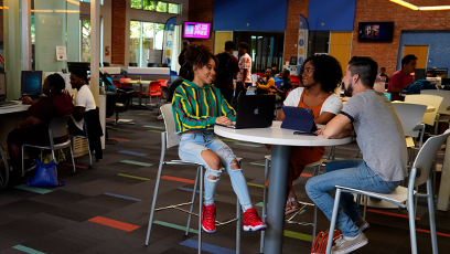 A group of college students sitting at a high top table engaged in conversation