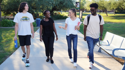 Four SCC students walking on campus engaged in conversation.