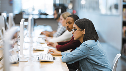A stock photo of colleges students using computers.
