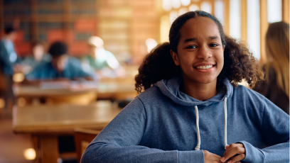 A smiling African American female high school student wearing a light blue hoodie