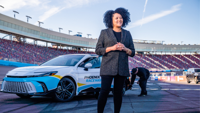 Latasha Causey standing on Phoenix Raceway's track in front of a car.