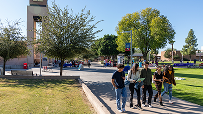 Five MCC students walking across the campus.