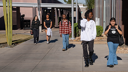 Five SMCC students walking across the campus