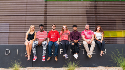 Image of seven students sitting outside of a building on GCC campus