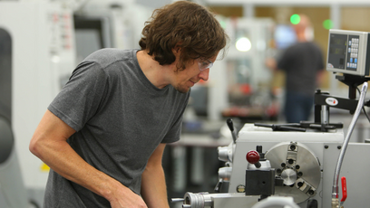 A student using a machine in a workshop