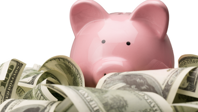 Image of a pink piggy bank with dollar bills
