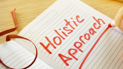 Image of a note book with the words Holistic Approach written in red in and underlined