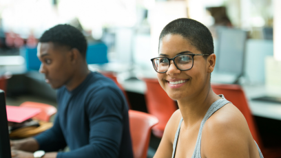 Image of a smiling woman and a man sitting beside her.