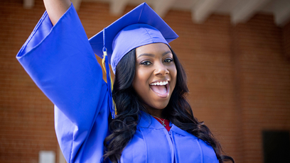 Image of a smiling graduate wearing a cap and gown