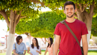 An image of a male college student wearing a red T-shirt with three women sitting on a bench in the background
