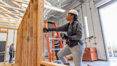 a woman construction worker framing a wall