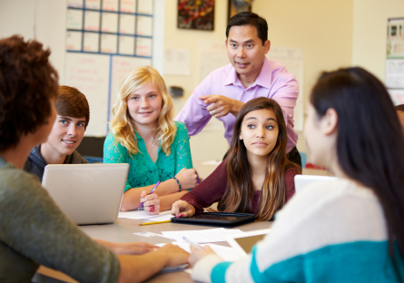 A stock image of high school students working in a small group with a teacher
