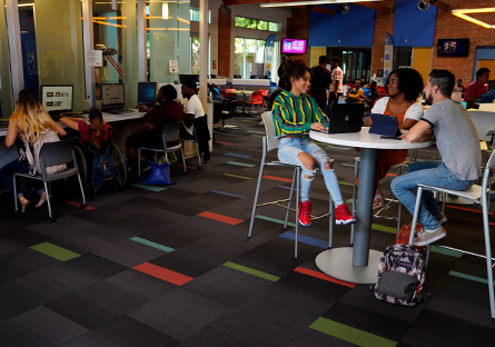 A group of college students sitting at a high top table engaged in conversation