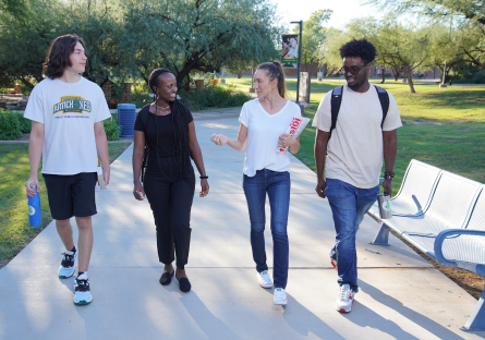 Four SCC students walking on campus engaged in conversation.