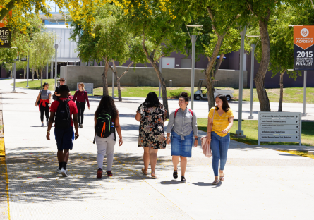 A photo with eight South Mountain Community College students walking across the campus.