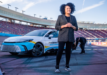 Latasha Causey standing on Phoenix Raceway's track in front of a car.