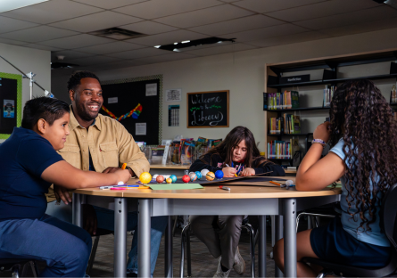 Gabriel Relf sitting at a table with three students
