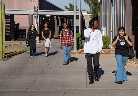 Five SMCC students walking across the campus