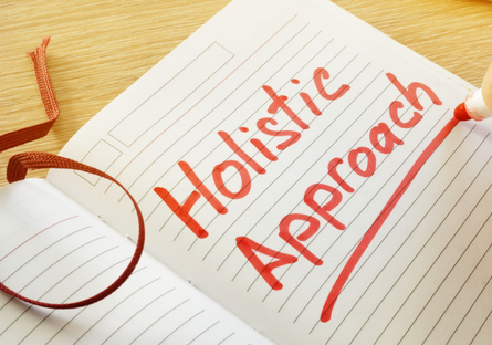 Image of a note book with the words Holistic Approach written in red in and underlined