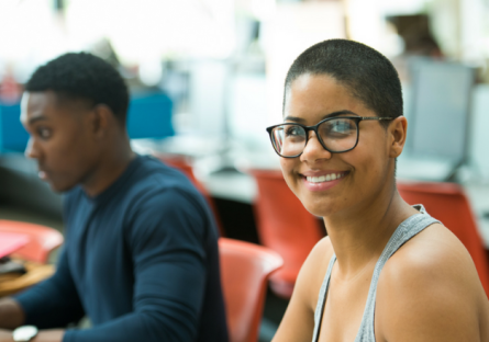 Image of a smiling woman and a man sitting beside her.