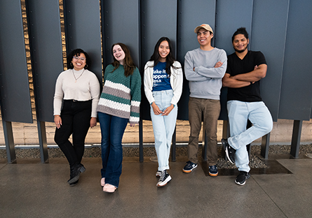 A group of five Maricopa Community Colleges students standing in front of levered panels