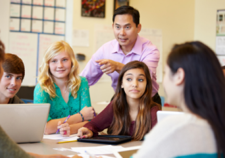 A stock image of high school students working in a small group with a teacher
