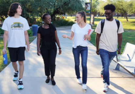 Four SCC students walking on campus engaged in conversation.