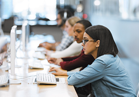 A stock photo of colleges students using computers.