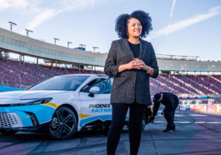 Latasha Causey standing on Phoenix Raceway's track in front of a car.