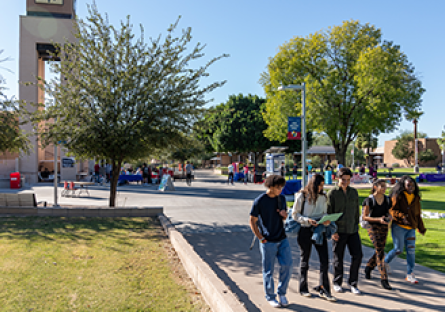 Five MCC students walking across the campus.