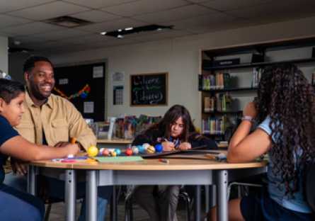 Gabriel Relf sitting at a table with three students