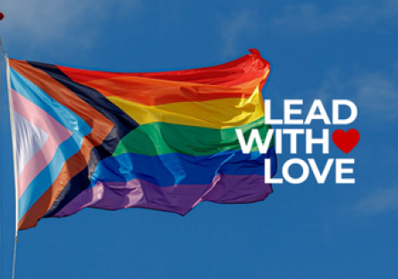 Pride Month flag with text reading "Lead with Love"