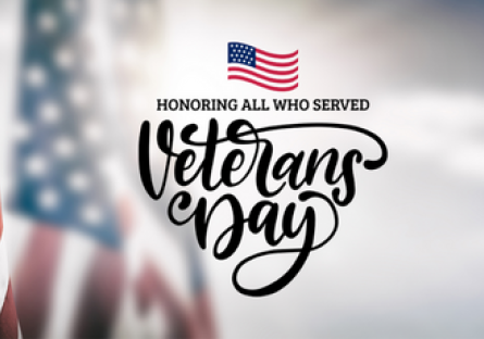A graphic with the American flag with the wording Honoring All Who Served Veterans Day