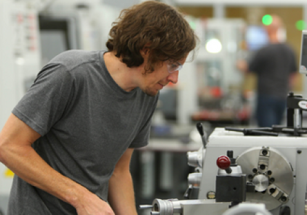 A student using a machine in a workshop