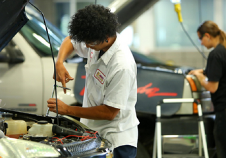 Image of students work on car engines in an Automotive class