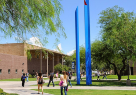 An exterior photo of the Paradise Valley Community College campus with students walking across the lawn