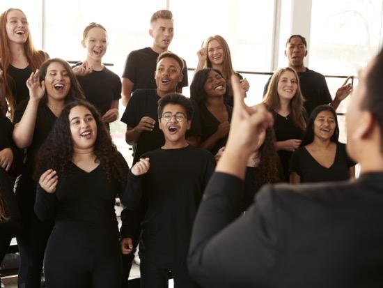 Choral students singing with conductor leading